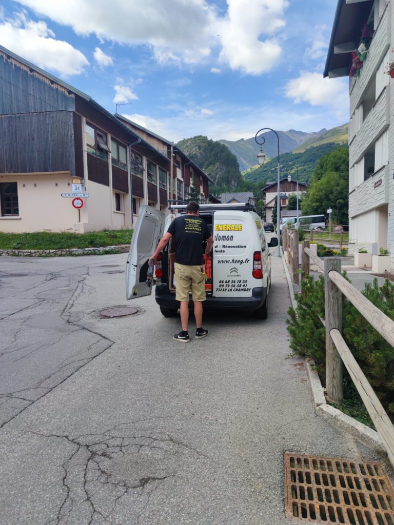 Salomon hervé derriere sont véhicule. il a ouvert la porte arrirer et nous tourne le dos.