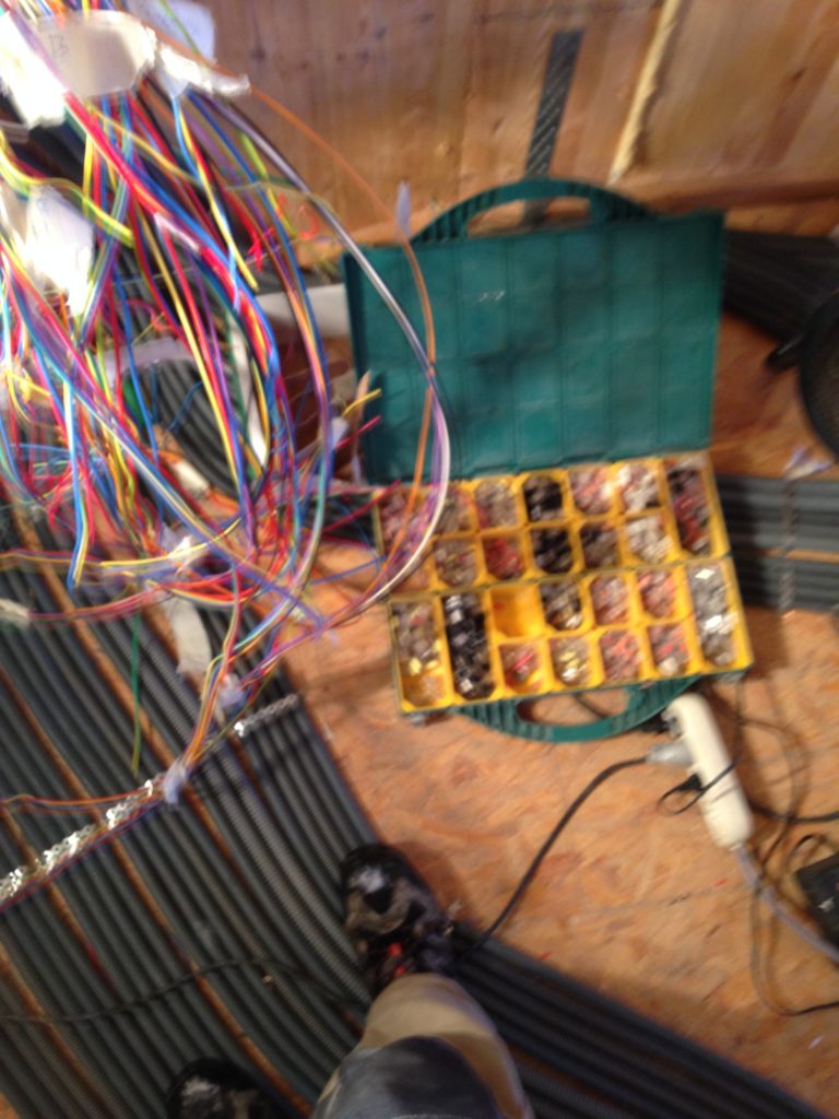 boite de domino electrique poser sur le sol. au dessus de la boite il y a une arriver de beaucoup de fils electrique. des arriver de gaines sont correctement positionné au sol.